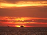 00395-1312 Tug and ship on the horizon of a setting sun at Miri - Sarawak - Photo by Garry K Smit